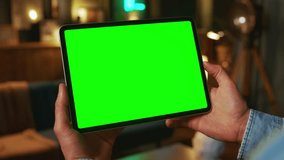 Close up hands holding on tablet computer with horizontal green screen. Mock up. In the evening. Work - Powered by Shutterstock - Get 15% off with code: PIKWIZARD15