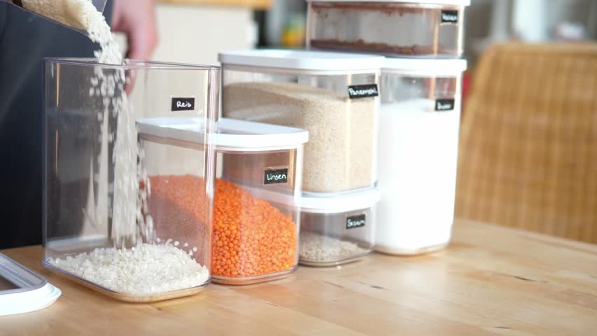 Organization of storage of cereals in the kitchen. Laying out products in a special transparent container.