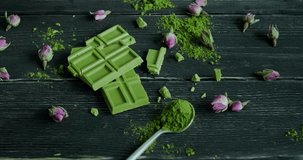 Woman tasting green matcha chocolate, person taking a piece of matcha white chocolate snack from table, slow motion video, close-up 4k footage