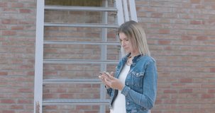 Young blonde woman having fun playing happily with smartphones. Use by millennials of cell phones and social applications. . High quality 4k footage