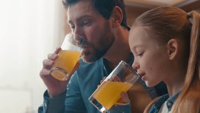 Happy family drinking orange juice at home Caucasian father with little daughter drink healthy fruit fresh at kitchen at breakfast dad with child kid girl talking enjoy organic juicy vitamin beverage - Powered by Shutterstock - Get 15% off with code: PIKWIZARD15