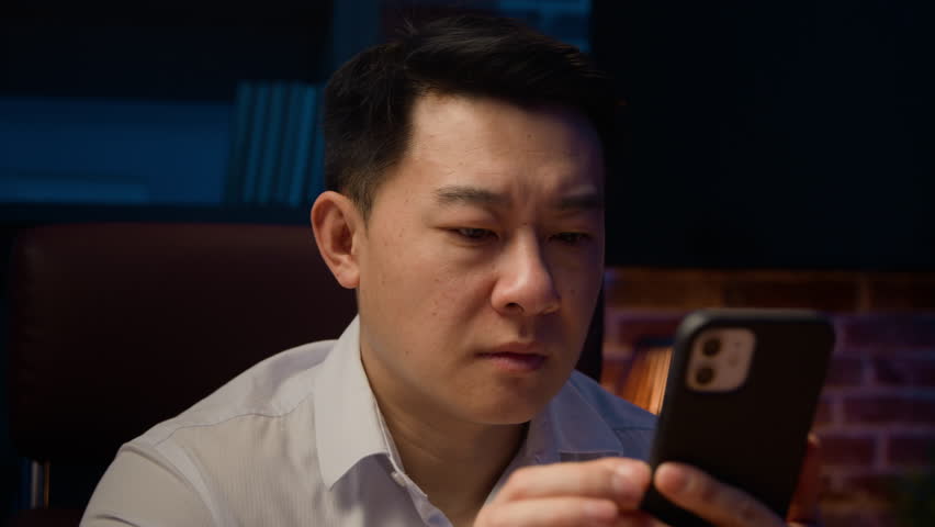 Asian adult man at night evening at home office lost failure with mobile phone sad unhappy Chinese male with smartphone lose bad news frustrated upset Korean middle-aged businessman cellphone problem Royalty-Free Stock Footage #1102704791