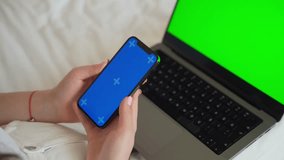 Close up teenage hands using smartphone green blue screen Chroma Key. Child girl scrolling over laptop app background Online entertainment education, online shopping, gaming, Mobile app, Using