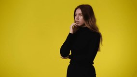 4k video of one girl having toothache over yellow background.