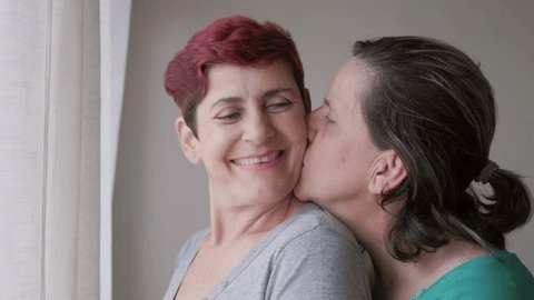 Gay senior lesbian couple hugging indoor at home - Diversity, LGBTQ lesbian family and love concept Video Stok