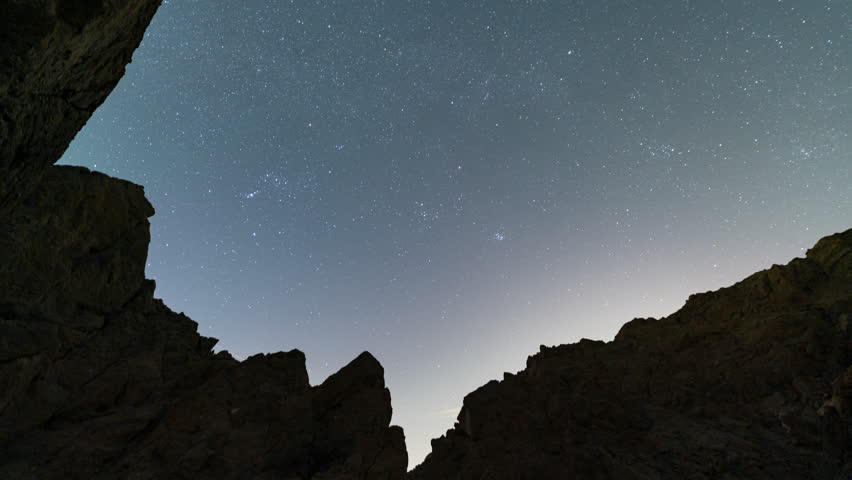 Time lapse of constellation Orion over desert mountain at night in Painted Canyon in California, USA