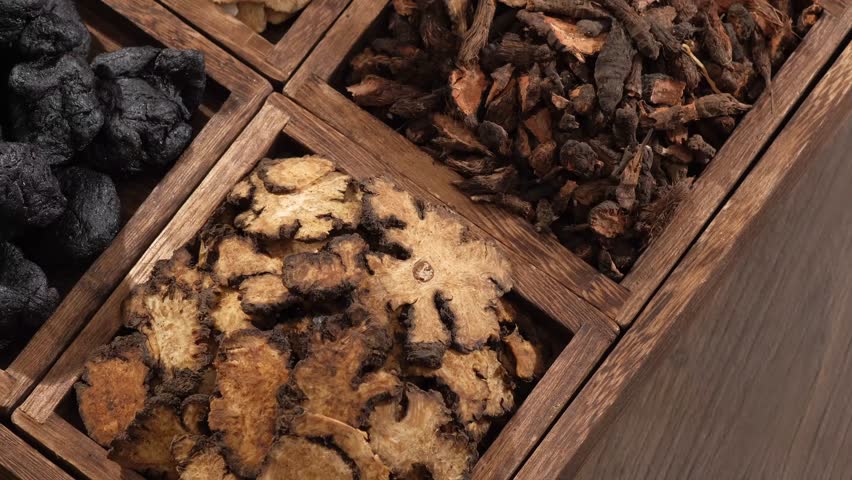 A wooden tray of Angelica root, Szechuan Lovage Rhizome and Bai Zhu. These herbs have the ability to treat health problems Royalty-Free Stock Footage #1102731121