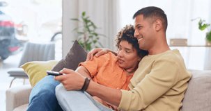 Video, love and entertainment with a couple watching tv on a sofa in the living room of their home together. Relax, film or television with a man and woman streaming series on a subscription service