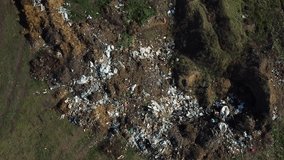 Aerial view of garbage pile in green field. Environmental concept. Drone footage.