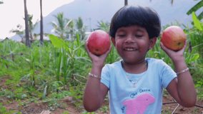 This video is about Girl holding two apples and enjoying babbling