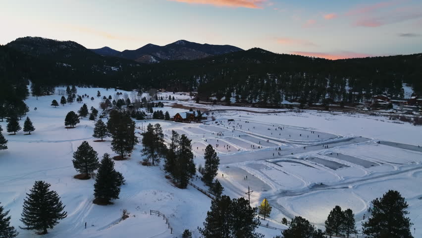 Mid winter Colorado sunset golden hour Evergreen Lake under lights playing hockey at various rinks cinematic circle