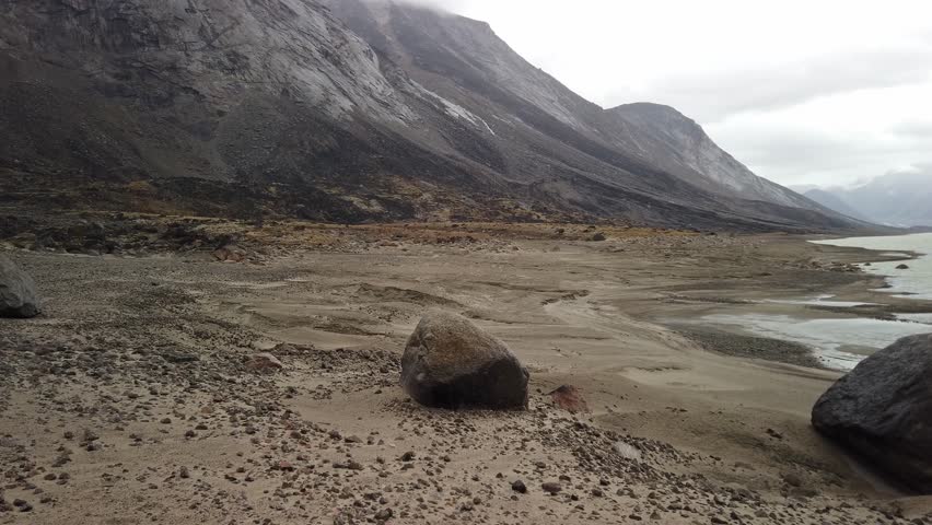 Panorama of Summit lake in the remote arctic wilderness of Baffin Island, Nunavut, Canada. Akshayuk pass hike in Auyuittuq national park. Cloudy day of arctic autumn.