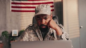 An African American officer is at his office at the army base, sitting at the desk and looking at laptop. - Powered by Shutterstock - Get 15% off with code: PIKWIZARD15