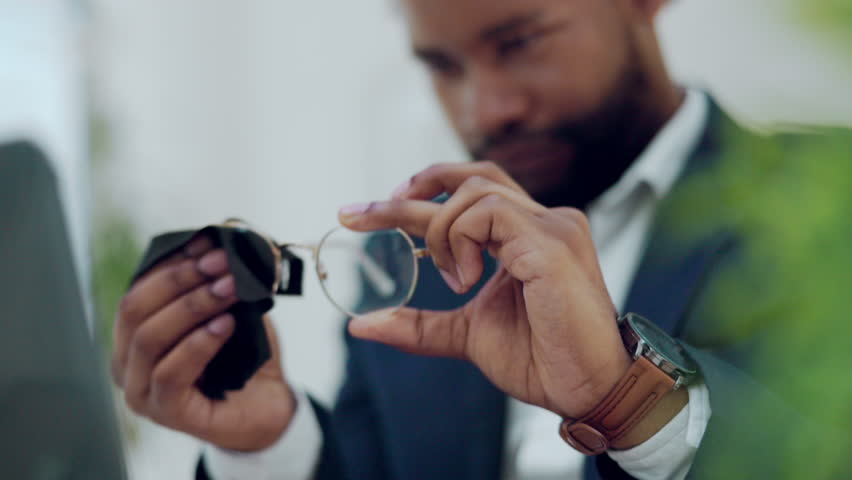Hands of man cleaning glasses, lens and eye care protection with fabric cloth in office. Closeup of male, business employee and wipe dust on spectacle frames, eyewear and maintenance for clear vision Royalty-Free Stock Footage #1102766261