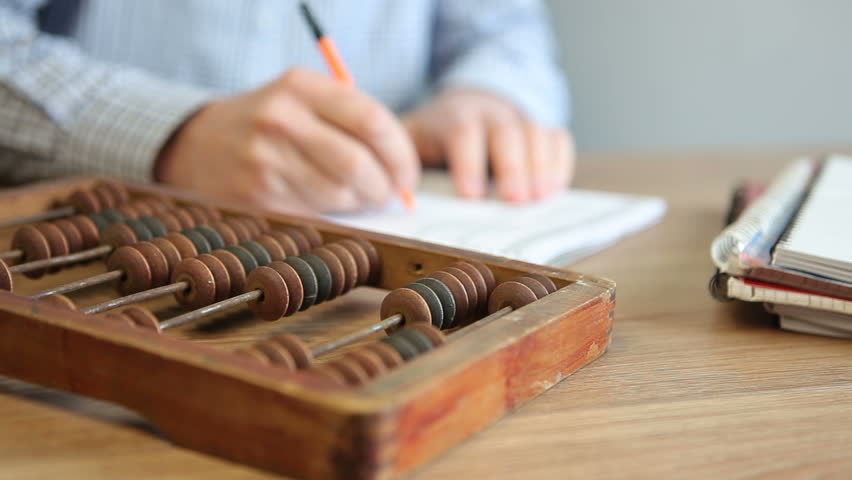 A male accountant counts on wooden abacus while sitting at a table in the office. Counting board with bones to perform arithmetic calculations. Royalty-Free Stock Footage #1102768979