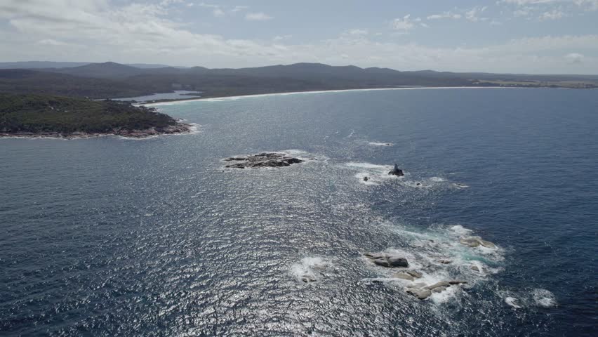 Sloop Rock - Solitary Rock Formations Jutting Out Of The Sea Near Sloop Rock Lookout In Tasmania, Australia. wide aerial Royalty-Free Stock Footage #1102769915