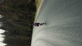 Cyclist sprinting while doing uphill cycling training. Vertical video. Pro road cyclist athlete pushing hard pedals, climbing uphill. Intense cardio workout exercises. Fitness activity. Cyling concept