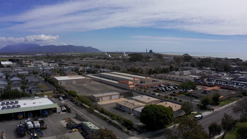 Reverse pullback aerial shot of an industrial park in Port Hueneme along the Pacific Ocean in California. 4K