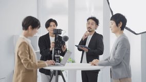 Young Asian video cameraman filming