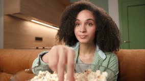 Woman Eating Popcorn Close Up. Smiling mixed race woman enjoys TV watching sitting on couch with popcorn bowl. - Powered by Shutterstock - Get 15% off with code: PIKWIZARD15