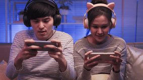 Young asian couple family playing online video games at home.
