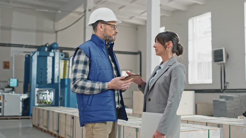 Young beautiful female executive present successfully cooperating with middle-aged interested Caucasian professional skillful experienced worker. Man show information on his new modern tablet.