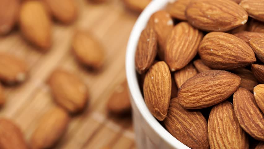 Almond nuts close up rotate in a circle. Nut almond close up. product rich in minerals and vitamins.  Almond kernels rotating.  A rotating shot of almonds. Texture of Almond kernels.  Royalty-Free Stock Footage #1102793019