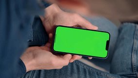Man Uses Phone With Green Screen Mock Up Display Sitting At Workplace In Office. Smartphone With Green Screen Close Up, Vertical Video