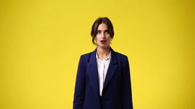4k video of one girl covering her mouth with her hands over yellow background.