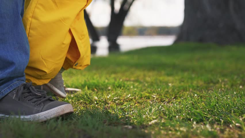 baby takes first steps in the park. happy family kid dream concept. baby steps on the green grass in the park first steps close-up. family dad teaches lifestyle baby son on the grass