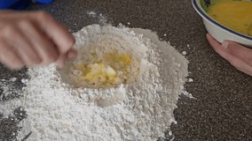 Stirring eggs in flour for pasta dough food preparing