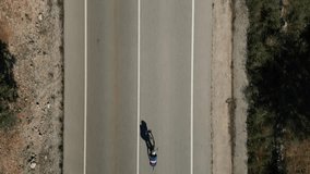 The silhouette of a cyclist on asphalt.Cyclist riding on time trial bike.Athlete is wearing sportswear and aero helmet.Man is preparing for the triathlon competition.Slow motion cycling video 4K.Spain