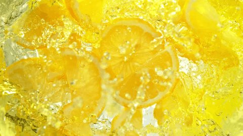 Super Slow Motion Shot of Fresh Lemon Slices Falling into Lemonade Whirl at 1000 fps. Video stock