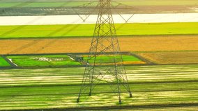 High voltage pole seen from an aerial drone would appear as a tall metal structure with insulators, wires, and transformers attached, often located in a line across the landscape. Industry concept
