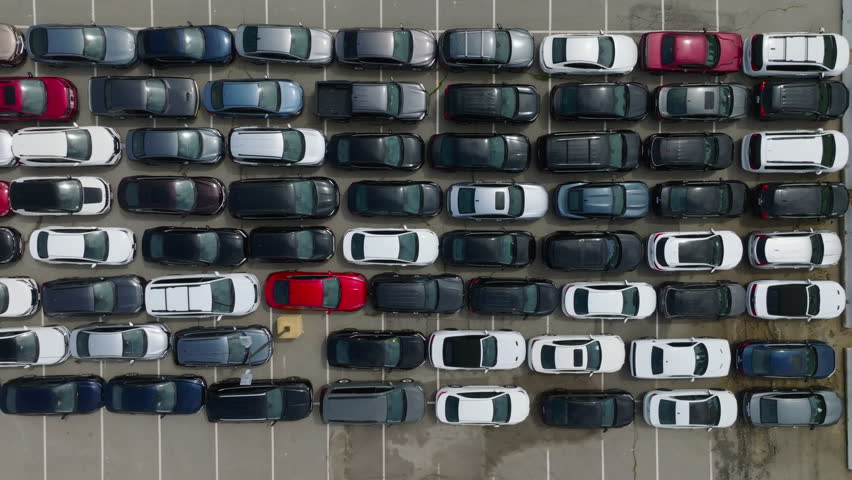 Aerial top view from drone of parking lot cars. Aerial view of the parked new cars. Drone flies over a large used car parking lot. Logistics transit. Car dealer parking lot full of new automobiles.  Royalty-Free Stock Footage #1102822151