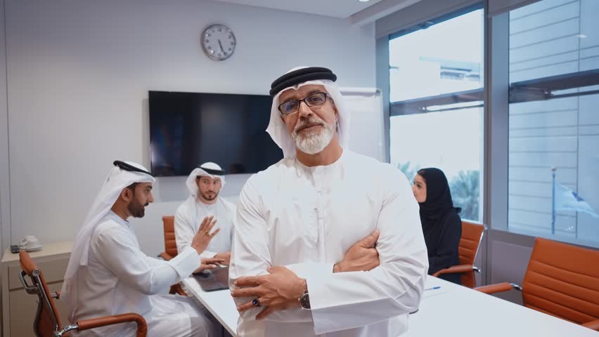 Business team at work in a office in Dubai. Locals from united arab emirates working on a new project wearing the formal traditional white outfit	 | Shutterstock HD Video #1102828359