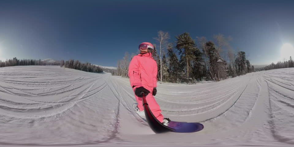 Snowboarding or skiing on winter snowy slope. Ski resort, winter sport. POV riding a snowboard. Rider in pink jacket, helmet. 360 degrees vr virtual reality video