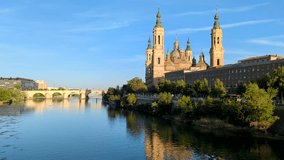 Discover the majesty of the Basilica del Pilar in Zaragoza as kayakers traverse the waters of the Ebro River in this exhilarating 4K video. 