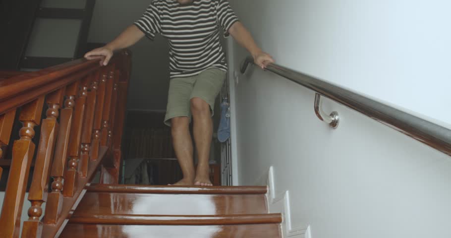 Asian man slowly going down staircase at home by holding handrail. Safety first at home concept. Royalty-Free Stock Footage #1102843377