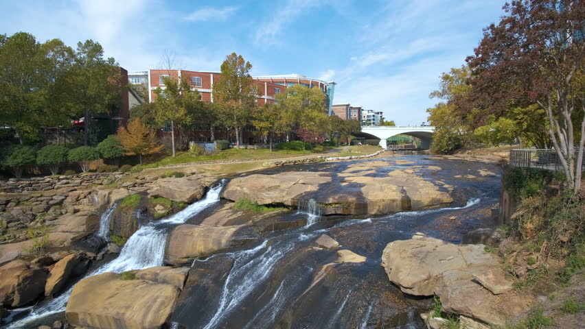 Reedy River Waterfalls in downtown of Greenville city in South Carolina. Falls Park riverwalk at Liberty bridge. American travel destination