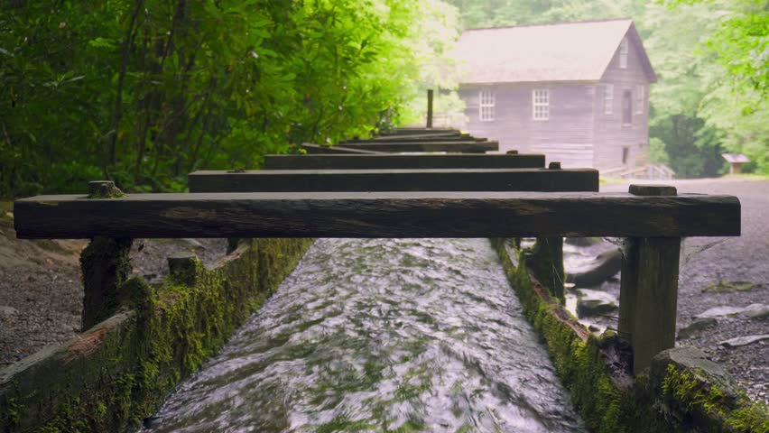 Mingus Mill at Great Smoky Mountains National Park. Water flows down a millrace to the mill. Historic gristmill was used for corn meal milling. 