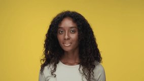Portrait of Young Black Woman Looking at Camera and Smiling in Color Studio Shot. Happy Adult Girl Isolated on Yellow Background Having Fun Close-up. African American Person with Nice Skin Turns Head - Powered by Shutterstock - Get 15% off with code: PIKWIZARD15