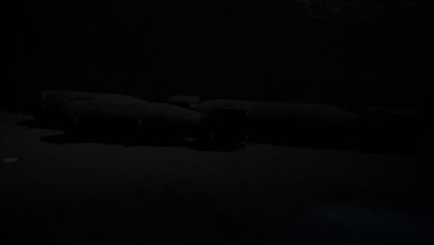 Capturing the atmosphere of World War II in flickering light: a secret underground shelter where bombs were stored and forgotten (covered with dust). Tension and danger among the explosive weapons.
