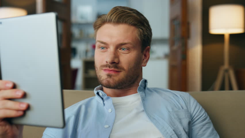 Surprised man reading tablet screen at house closeup. Wondering guy watching tab computer making wow expression at home zoom out. Amazed freelancer holding digital pad device getting positive results Royalty-Free Stock Footage #1102856185