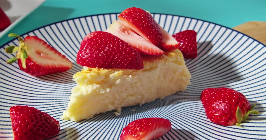 Piece of delicious cottage cheese cake with strawberries, poured with chocolate on a blue plate. Delicious snack, closeup food and drink background