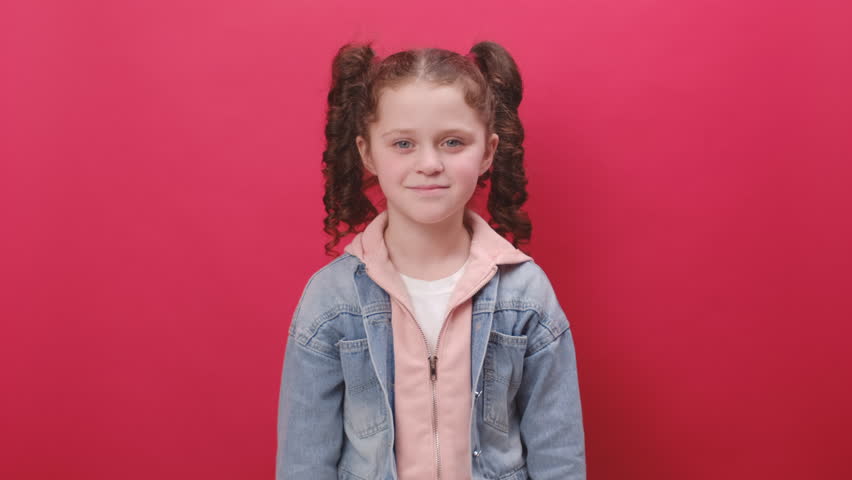 Portrait of happy cute little girl kid looking approvingly at camera showing thumbs up, like sign positive something good, positive feedback, posing isolated over red studio background. Like concept | Shutterstock HD Video #1102857757