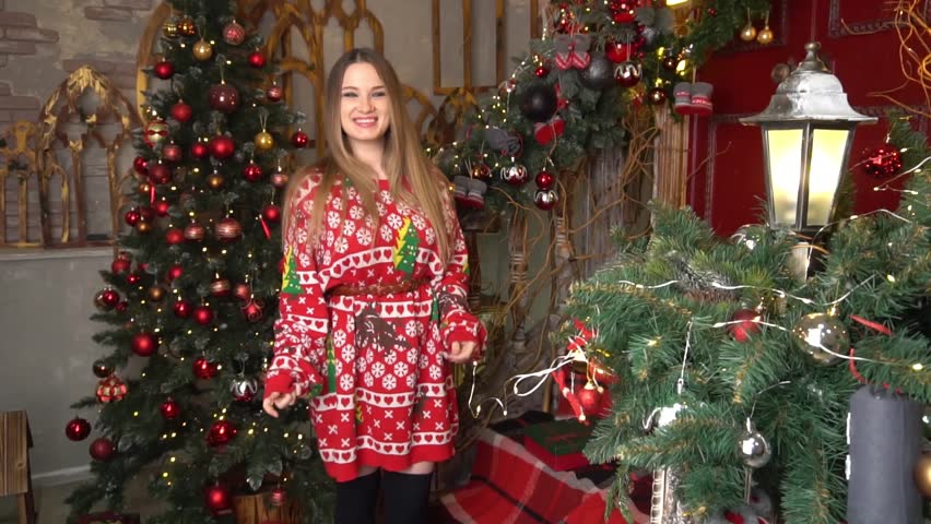Girl in the red sweater, having fun and posing against the backdrop of Christmas