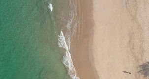 Vertical drone video on a tropical sandy beach and the sea at daytime