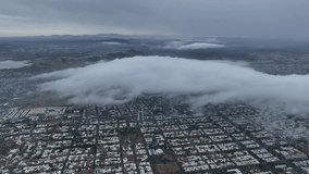 Drone flight over city with cloudy weather shot shadowy