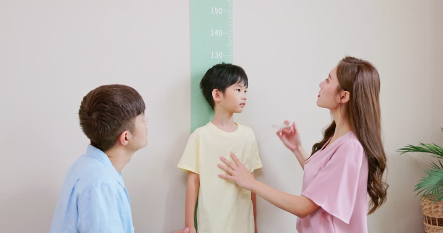 closeup asian parents help their boy doing height measurement with worry about his shortness make parenths a bit depression Royalty-Free Stock Footage #1102866599